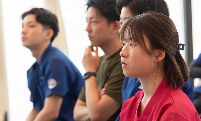 学びの場で真剣に話を聞くスタッフ